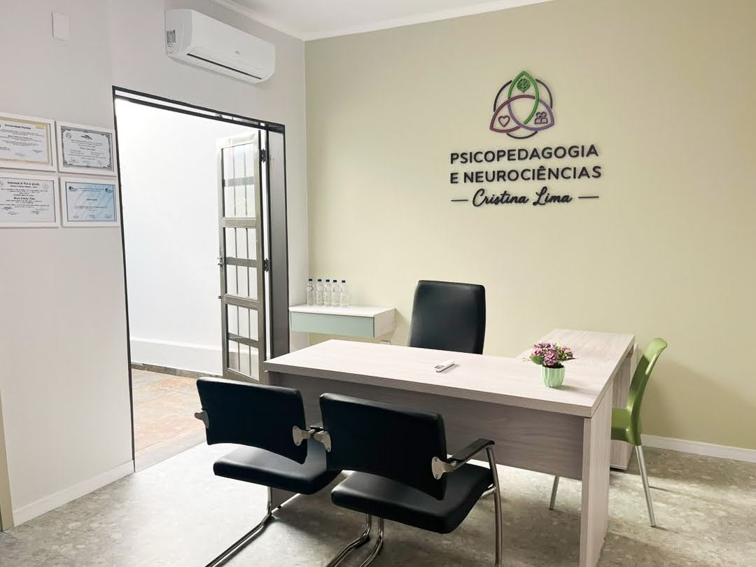 Consultório de Cristina Lima com mesa de atendimento e identidade visual na parede